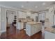An open kitchen features white cabinets, stainless steel appliances, wood floors, and granite countertops at 3174 Piney Woods Cir, Buford, GA 30519