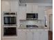 Modern kitchen featuring stainless steel appliances, granite countertops, and white cabinetry for a clean and stylish design at 3174 Piney Woods Cir, Buford, GA 30519
