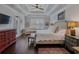 A main bedroom featuring a sitting area, tray ceilings, and wood floors at 3174 Piney Woods Cir, Buford, GA 30519