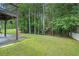 A large lush green backyard with a patio area beneath a second story deck at 3885 Weeping Willow Ln, Loganville, GA 30052