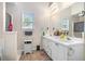 Bright bathroom featuring double vanity, framed mirror and a window bringing in natural light at 3885 Weeping Willow Ln, Loganville, GA 30052