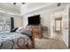 Comfortable bedroom featuring neutral carpet, a tray ceiling, and a decorative wooden dresser at 3885 Weeping Willow Ln, Loganville, GA 30052
