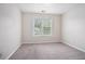 Bright bedroom featuring neutral walls, carpet, natural light from the large window and electrical outlets at 3885 Weeping Willow Ln, Loganville, GA 30052