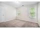 Bright bedroom featuring neutral walls, plush carpeting, and large windows for ample natural light at 3885 Weeping Willow Ln, Loganville, GA 30052