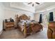 Spacious bedroom featuring decorative tray ceilings, a ceiling fan and a large decorative wooden bed frame at 3885 Weeping Willow Ln, Loganville, GA 30052