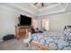 Inviting bedroom features neutral walls, carpet and a tray ceiling with view into ensuite bathroom at 3885 Weeping Willow Ln, Loganville, GA 30052