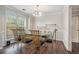 Bright dining room featuring hardwood floors, decorative molding, and a glass-topped table with seating for six at 3885 Weeping Willow Ln, Loganville, GA 30052