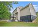 Back exterior view of the home with a patio, second story deck, and green lawn at 3885 Weeping Willow Ln, Loganville, GA 30052