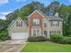 Traditional two-story home featuring brick and siding with a well-manicured front lawn and an attached two-car garage at 3885 Weeping Willow Ln, Loganville, GA 30052