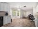 Bright kitchen with white cabinets, tile flooring, and a view to the adjacent living area at 3885 Weeping Willow Ln, Loganville, GA 30052