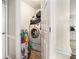Compact laundry area with a stacked washer/dryer and shelving for storage at 3885 Weeping Willow Ln, Loganville, GA 30052