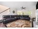 Inviting living room features a large leather sectional sofa, fireplace, ceiling fan, and stylish area rug at 3885 Weeping Willow Ln, Loganville, GA 30052