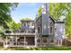 View of the rear exterior of the home with multiple decks, windows and mature trees surrounding the property at 8260 Overview Ct, Roswell, GA 30076
