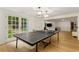 Basement recreation room features a ping pong table, French doors to yard, recessed lights and minibar at 8260 Overview Ct, Roswell, GA 30076