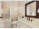 Well-lit bathroom featuring a toilet, sink, mirror, and shower with gold accents at 8260 Overview Ct, Roswell, GA 30076