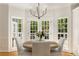 Bright breakfast area with white dining set with a chandelier overhead and natural light from the windows at 8260 Overview Ct, Roswell, GA 30076