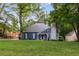Landscaped lawn and traditional-style home with blue siding and a stone chimney at 8260 Overview Ct, Roswell, GA 30076