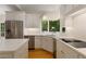 Modern kitchen with white cabinets, stainless steel appliances, corner window, and a sleek cooktop for culinary enthusiasts at 8260 Overview Ct, Roswell, GA 30076