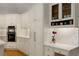 Bright kitchen featuring custom white cabinets, built-in oven, and a decorative display shelf for stylish storage at 8260 Overview Ct, Roswell, GA 30076