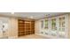 A neutral room with hardwood floors, built in bookcase and French doors that lead to the exterior at 8260 Overview Ct, Roswell, GA 30076