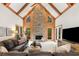Spacious living room with a stone fireplace, wood beams, and large windows offering natural light at 8260 Overview Ct, Roswell, GA 30076