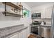 Stylish kitchen featuring stainless steel appliances, granite countertops, white cabinets, and natural light at 120 Biscayne Nw Dr # C13, Atlanta, GA 30309