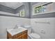 Bathroom featuring white tiled walls, a light wood vanity, and natural light at 1911 Rosewood Rd, Decatur, GA 30032