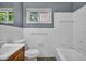 Standard bathroom with white tiled walls, window and modern sink, tub and toilet at 1911 Rosewood Rd, Decatur, GA 30032