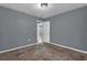 Carpeted bedroom with light coming in through the door, neutral walls and a ceiling light at 1911 Rosewood Rd, Decatur, GA 30032