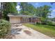 Cozy single-story home featuring a classic brick facade and a cracked concrete driveway at 1911 Rosewood Rd, Decatur, GA 30032