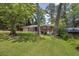 Charming brick home nestled among mature trees with a sprawling front lawn at 1911 Rosewood Rd, Decatur, GA 30032