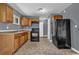 Kitchen with wood cabinets, black appliances, tile floors, and gray walls at 1911 Rosewood Rd, Decatur, GA 30032