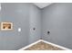 An empty laundry room with grey walls and a tile floor with connections ready for a washing machine at 1911 Rosewood Rd, Decatur, GA 30032