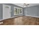 Bright living room with hardwood floors, ceiling fan and a large window looking out to a nice yard at 1911 Rosewood Rd, Decatur, GA 30032