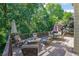 Wooden back deck with seating, dining, and fire pit area surrounded by lush trees at 765 Vinings Estates Se Dr, Mableton, GA 30126