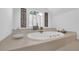A luxurious soaking tub situated under a shuttered window offers a relaxing retreat at 765 Vinings Estates Se Dr, Mableton, GA 30126