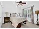 A bright bedroom features a ceiling fan, neutral decor, and a large window with views of the outdoors at 765 Vinings Estates Se Dr, Mableton, GA 30126