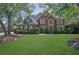 Beautiful two-story brick home boasts a manicured lawn and mature trees at 765 Vinings Estates Se Dr, Mableton, GA 30126