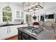 A stylish kitchen features white cabinets, granite counters, stainless steel appliances, and a central island cooktop at 765 Vinings Estates Se Dr, Mableton, GA 30126