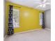 A bedroom with bright yellow walls and black-out curtains by two windows at 1050 Hampton Hill Ct, Lawrenceville, GA 30044