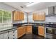 A kitchen featuring light wood cabinets, stainless steel appliances, and a black countertop at 1050 Hampton Hill Ct, Lawrenceville, GA 30044