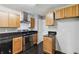 A kitchen featuring light wood cabinets, stainless steel appliances, and a black countertop at 1050 Hampton Hill Ct, Lawrenceville, GA 30044