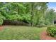 Manicured backyard featuring a well-maintained lawn, mulch beds, mature trees and a wood fence along the perimeter at 1942 N Akin Ne Dr, Atlanta, GA 30345
