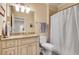 Bathroom featuring vanity with granite countertops, white cabinets, tiled walls, and a neutral shower curtain at 1942 N Akin Ne Dr, Atlanta, GA 30345