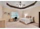 Cozy bedroom with tray ceiling, neutral walls, a workstation by window, and an inviting bed for relaxation at 1942 N Akin Ne Dr, Atlanta, GA 30345