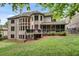 View of a home's rear exterior featuring a screened porch, deck, brick facade, and lush lawn at 1942 N Akin Ne Dr, Atlanta, GA 30345