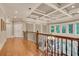 Upper hallway with hardwood floors, paneled walls, and views of the lower level windows at 1942 N Akin Ne Dr, Atlanta, GA 30345