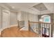 Hallway with wooden floors, decorative iron railing, and a view of the entry and staircase at 1942 N Akin Ne Dr, Atlanta, GA 30345