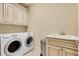 Functional laundry room with side-by-side washer and dryer, sink, and cabinets for organized storage and convenience at 1942 N Akin Ne Dr, Atlanta, GA 30345
