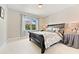 Comfortable bedroom with a dark wood bed frame, large window, and neutral decor at 3456 Glen Mist Pl, Dacula, GA 30019